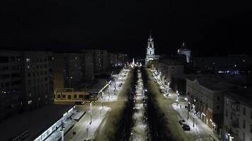 natt vägkorsning med bilar rörelse i en små stad. klämma. antenn se av stad gator och upplyst byggnader. foto