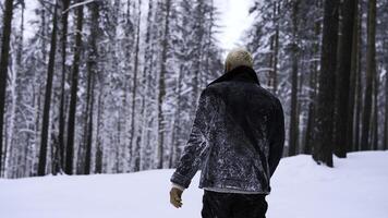 ensam man gående genom snö. media. ung kille med snö på hans jacka känsla ensam och isolerat i kall skog. foto