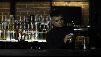 de bearbeta av framställning ett alkoholhaltig cocktail på de bar. media. ung manlig bartender på arbete. foto