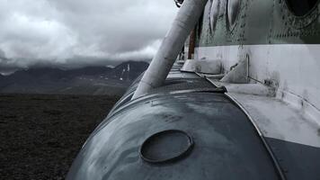 stänga upp av gammal rostig flygplan på en kulle topp. klämma. flygplan exteriör detaljer med tung moln och bergen på de bakgrund. foto