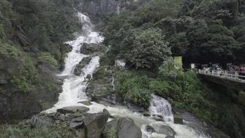 skön tropisk vattenfall i djungel med vandring stigar. handling. cascading vattenfall på stenar av regnskog. skön turist vattenfall med kaskader på stenar i grön djungel foto
