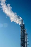 tre rykande pipor mot den blå himlen. begreppet miljöförorening. foto