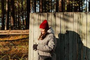 höst mode, medelålders kvinna poser snyggt förbi riden staket på solig dag foto