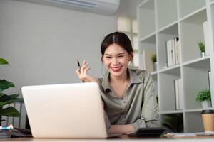 asiatisk företag kvinna använder sig av bärbar dator till analys Graf finansiell budget Rapportera och planera för framtida i kontor skrivbord foto