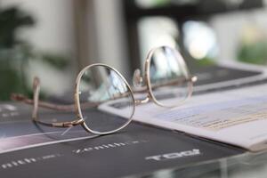 glasögon på tabell, progressiv linser, glasögon för de äldre, glasögon progressiv lins, monokel progressiv lins, närbild av glasögon på linser testa, ser genom glasögon foto