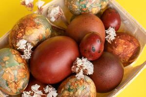 sortiment av påsk ägg med naturlig blad mönster i en trä- korg foto