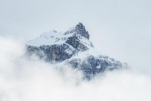 majestätisk, snötäckt topp svävar ovan de moln i Engelberg, schweiz. foto