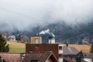 engelberg by klocka torn mitt i dimmig berg, schweiz foto