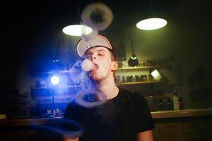 de man rök ett elektronisk cigarett på de vape affär foto