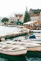 vit trä- fiske båtar är förtöjd på de pir. perast, monte foto