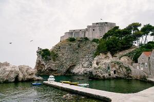 båtar är förtöjd i en små bukt nära de fästning vägg. dubrovnik, kroatien foto