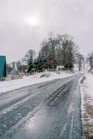 isig väg i en snöig by med mysigt hus foto