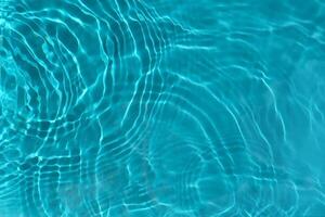transparent turkos klar vatten yta textur med krusningar, vågor och ringar i solljus. foto