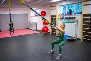 Träning i de Gym för de figur korrektion. ung kvinna håller på med kondition övningar på Gym. hög kvalitet Foto