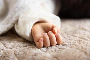 en vänster hand av sovande asiatisk bebis på de matta foto