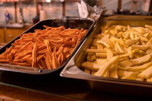 till typer av smaskigt franska frites i de metall brickor. potatis pommes frites på de disken på de gata marknadsföra. selektiv fokus. sida se. bokeh. foto