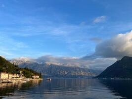 perast vägbank med förtöjd fiske båtar på de fot av de berg. monte foto