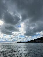 åskmoln i de himmel ovan de hav på de fot av de bergen foto