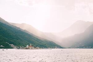 ö av gospa od skrpjela i de bukt av kotor mot de bakgrund av bergen i de solljus. monte foto