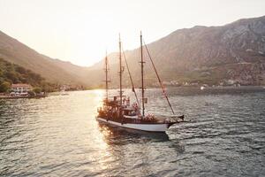 segelbåt segel på de hav med turister på styrelse längs de bergig kust foto