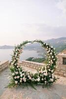 runda bröllop båge står på ett observation däck på en berg ovan de hav foto