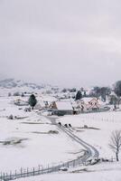 kor promenad längs de väg i en snöig by i en berg dal. tillbaka se foto