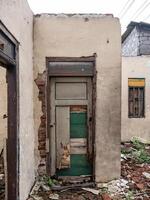 en bruten dörr på en hus den där har varit övergiven för en lång tid foto
