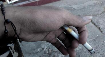 stänga upp av en cigarett i de händer av ett gammal man. fotografi konst begrepp foto