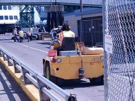 björk bukt, va, 2006 - docka arbetstagare körning gul gaffeltruck från tillbaka foto