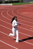 ung svart kvinna löpning på Spår svettas kostym foto