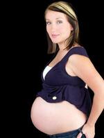 ung gravid kvinna som visar stor bar mage foto