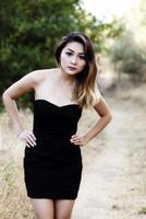 attraktiv asiatisk amerikan kvinna stående utomhus svart klänning foto