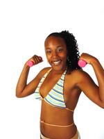 leende afrikansk amerikan kvinna innehav små rosa vikter foto