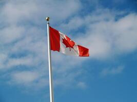 kanadensisk flagga flygande på Pol mot himmel foto