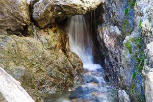 små vattenfall lång exponering med bäck och stenar foto