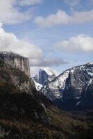 avlägsen se halfdome och dal blå himmel moln snö foto