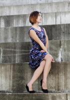 ung smal attraktiv asiatisk amerikan kvinna Sammanträde i klänning foto