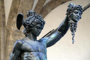 detalj av perseus innehav huvud av medusa, brons staty i loggia de lanzi, piazza della Signoria, Florens, Italien. isolerat på vit foto