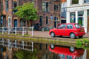 bilar på kanal vägbank i gata av delft. delft, nederländerna foto