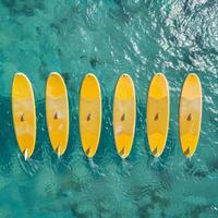 ai genererad en uppsättning av gul surfingbrädor på en blå hav bakgrund foto