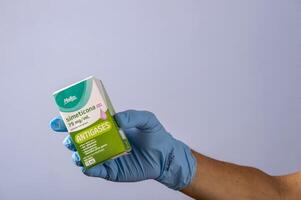 rio, Brasilien - januari 27, 2023, hand med skyddande sudd handske innehav medicin låda, simetikon foto