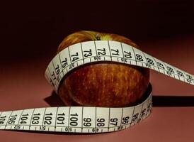 tejp mäta och äpple symboliserar diet och fetma foto