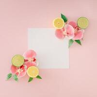 trendig layout tillverkad med orkide blommor, kalk, citroner, grön löv och papper kort notera kopia Plats på ljus rosa bakgrund. kreativ mat begrepp. minimal citrus- frukt med blommor aning. platt lägga. foto