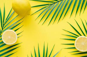 kreativ trendig sommar sammansättning tillverkad med citroner och tropisk grön handflatan löv på ljus gul bakgrund. frukt minimal begrepp. exotisk natur platt lägga. foto