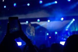 hand med en smartphone uppgifter leva musik festival, tar Foto av konsert skede, leva konsert, musik festival