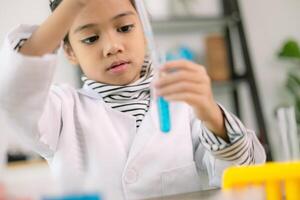 asiatisk barn flicka inlärning vetenskap kemi med testa rör framställning experimentera på skola laboratorium. utbildning, vetenskap, kemi, och barns begrepp. tidigt utveckling av barn. foto