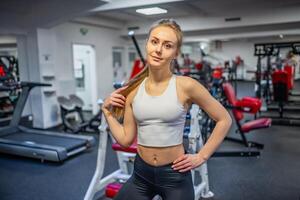 ung sportig kvinna bär sportkläder Framställ innan håller på med övning med kondition Utrustning på Gym, hon övning för stark och Bra foto