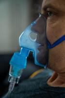 ohälsosam man bär nebulisator mask i Hem. hälsa, medicinsk Utrustning och människor begrepp. hög kvalitet Foto
