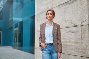 affärskvinna framgångsrik kvinna företag person stående utomhus- företags- byggnad exteriör. pensiv caucasian förtroende professionell företag kvinna mitten ålder foto