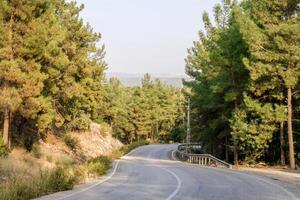 berg väg genom en grön skog. lantlig se nära till doyran damm, antalya, Kalkon. foto